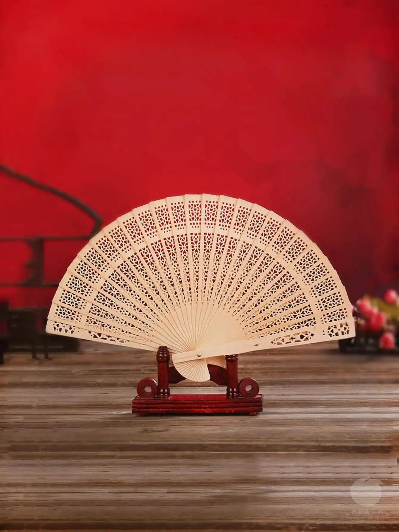 Hand holding opened Chinese fan demonstrating proper grip and graceful positioning.