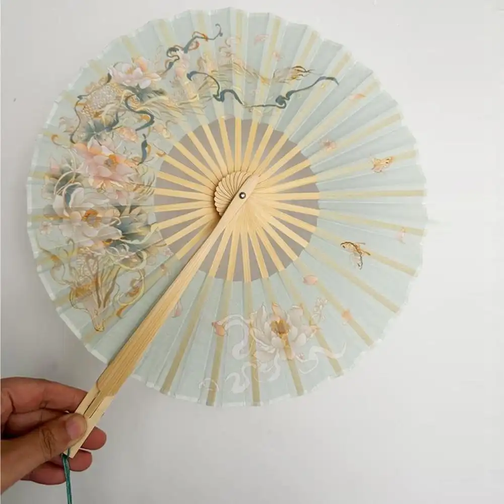 Traditional dance performance featuring round bamboo fan as cultural accessory.