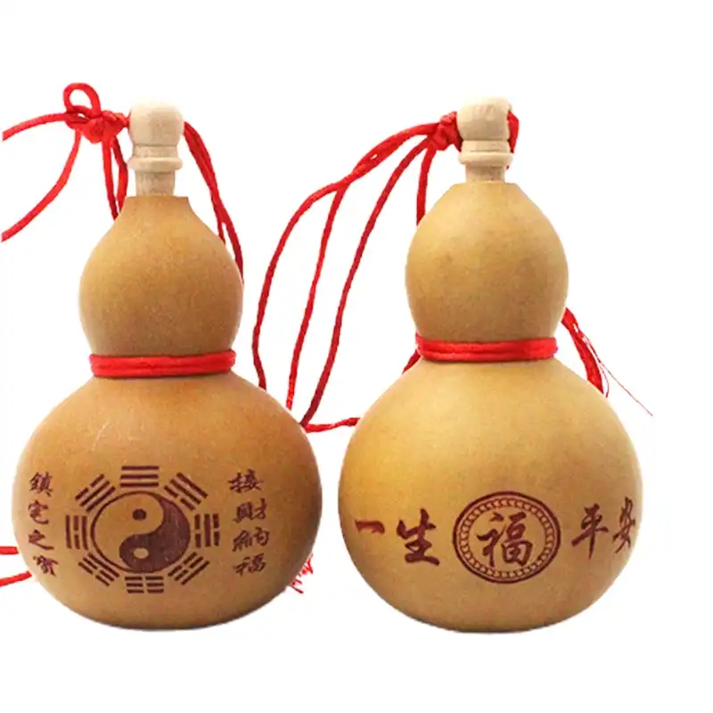 Detailed view of carved Chinese characters and gossip patterns on mini wine gourd decoration.