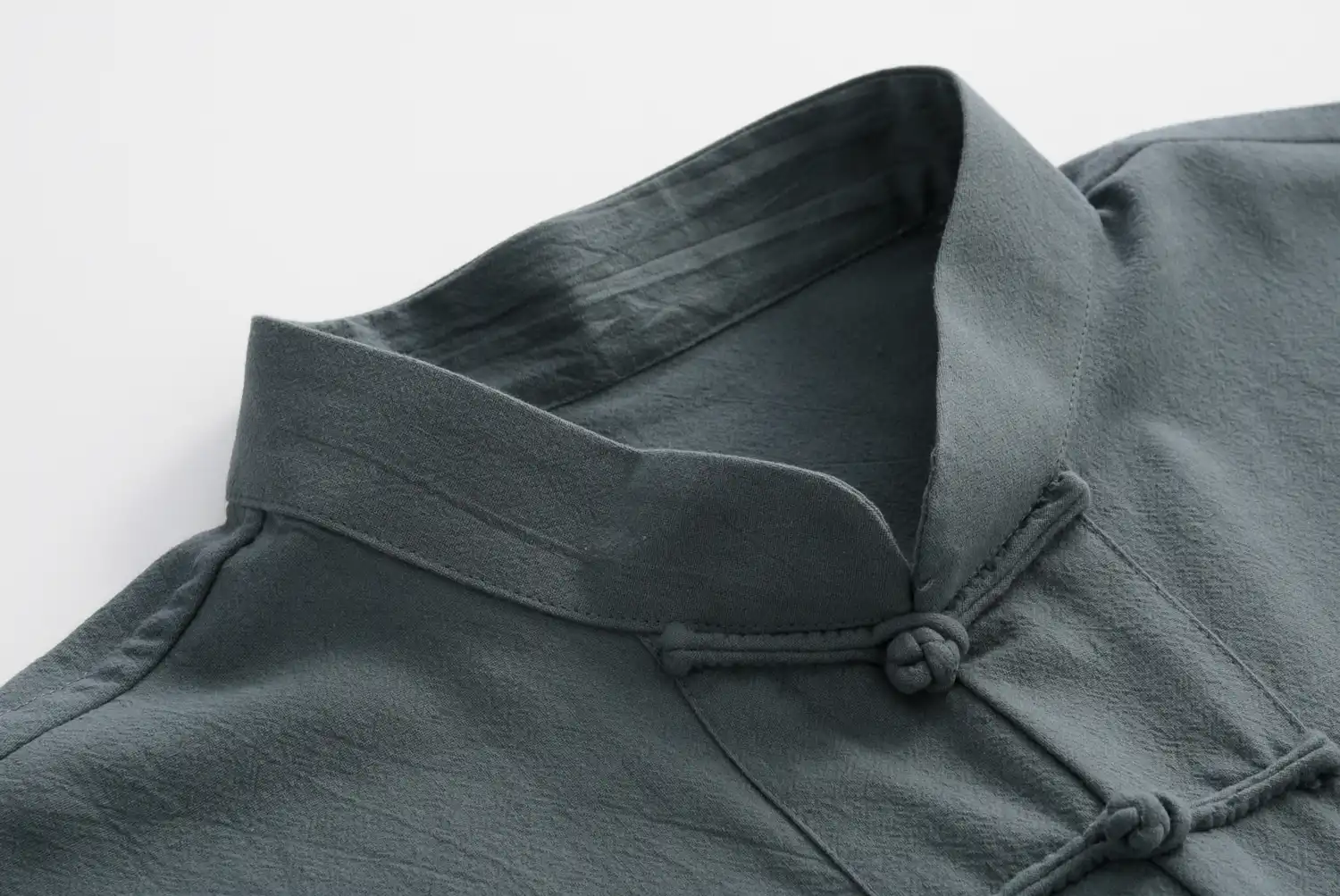 Flat lay of navy blue tang suit showing traditional Chinese tailoring and stitching.