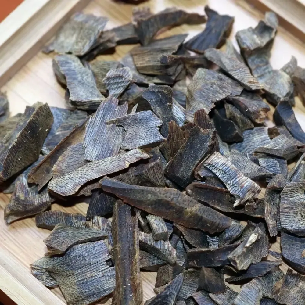 ​​Premium Vietnam oud chips 100g package showing natural sinking wood texture and resin quality.