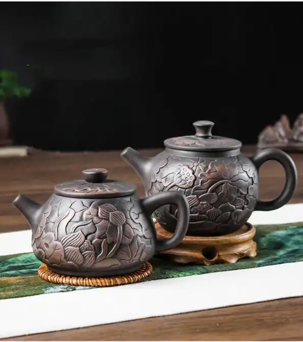 Tea brewing demonstration using hand carved lotus Yixing teapot with golden tea color display.