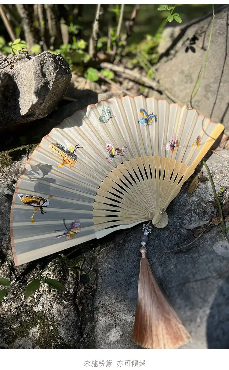 Japanese embroidered folding fan used as cultural prop in traditional ceremony setting.