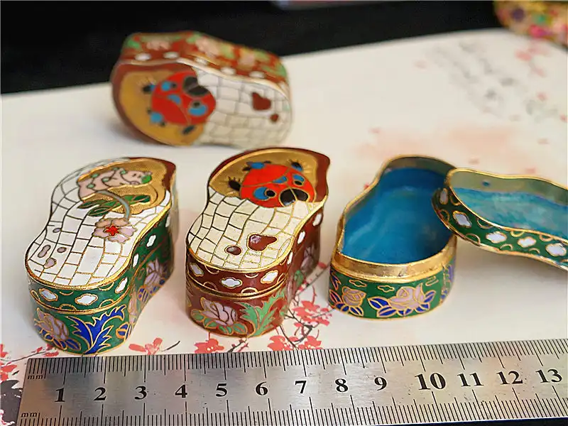 Close examination of cloisonne box edges showing authentic copper wire compartment construction.