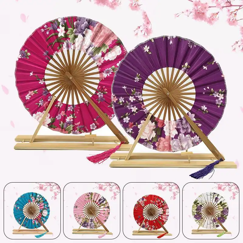 Professional model using Japanese round fan as elegant accessory at outdoor wedding event.
