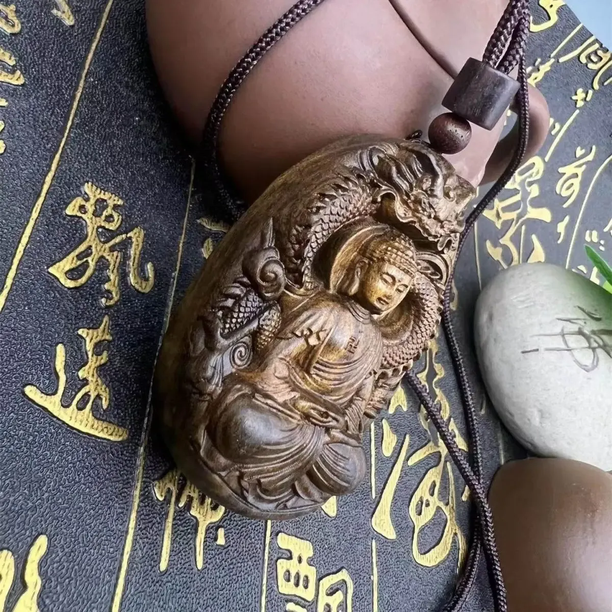 Person wearing sandalwood Buddha pendant necklace for spiritual protection and mindfulness.