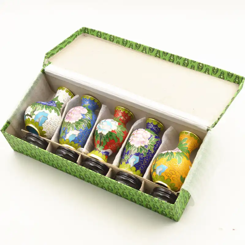 Set of five traditional Chinese cloisonne vases with intricate enamel patterns and gold accents.