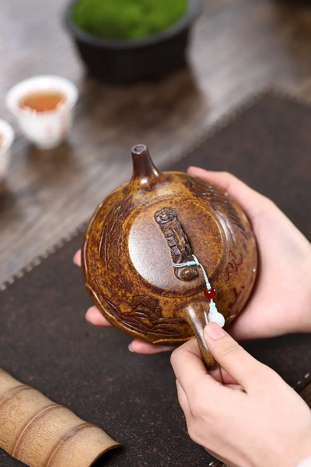 Traditional tiger mountain view design elements carved into keel gold sand purple clay surface.
