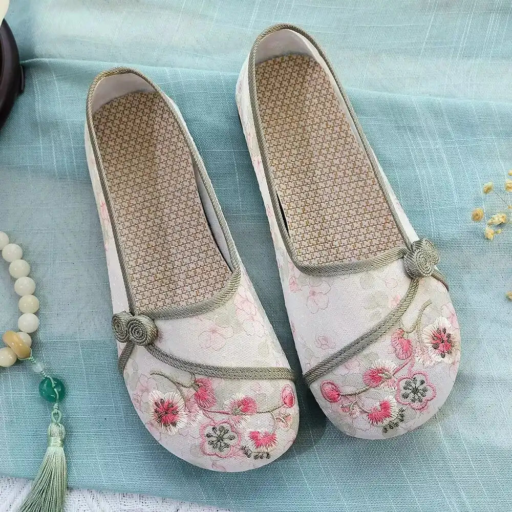 Close-up view of intricate floral embroidery detail on Old Beijing cloth shoe upper material.