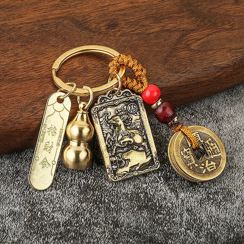 Feng shui brass gourd keychain with copper coins attached to car keys for wealth protection.