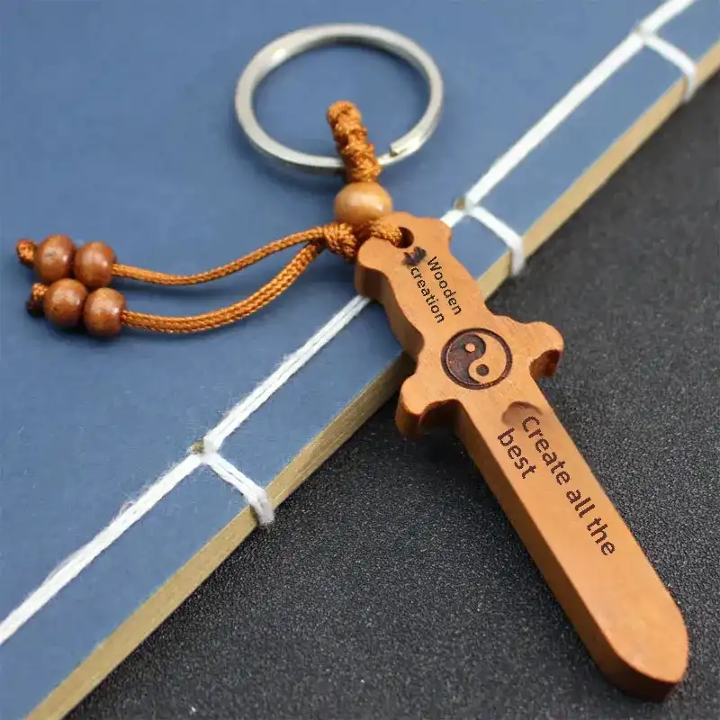 Multiple peach wood sword keychains displayed showing handcrafted variations and unique designs.