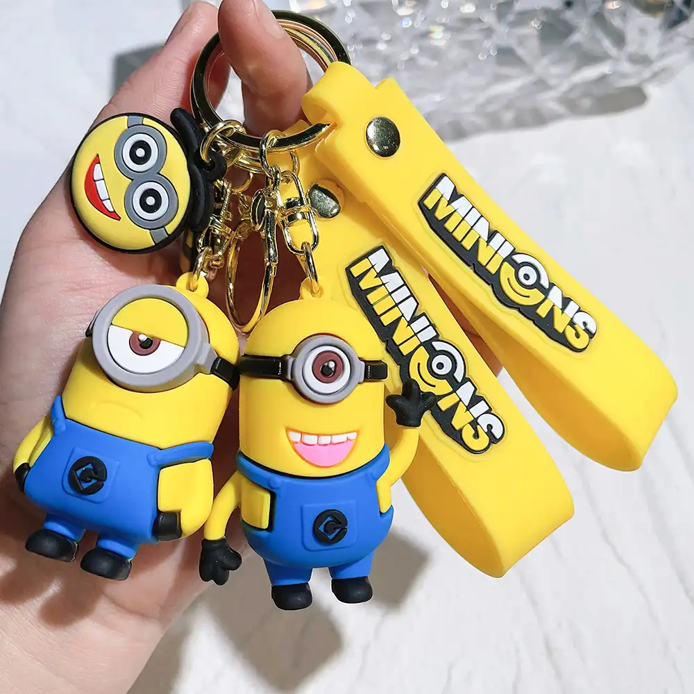 Minions bag charm hanging from stylish handbag handle demonstrating practical everyday use.
