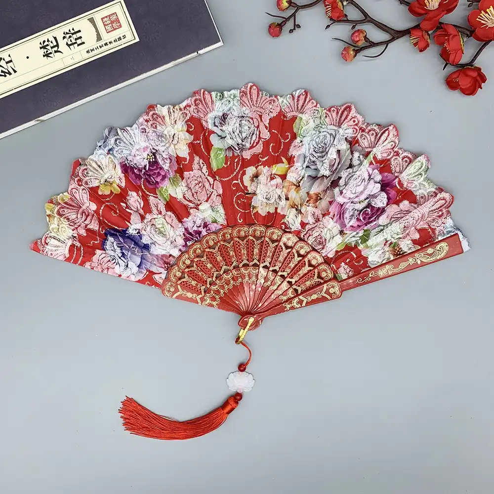 Japanese silk fan used as elegant prop in cosplay photoshoot with dramatic lighting.