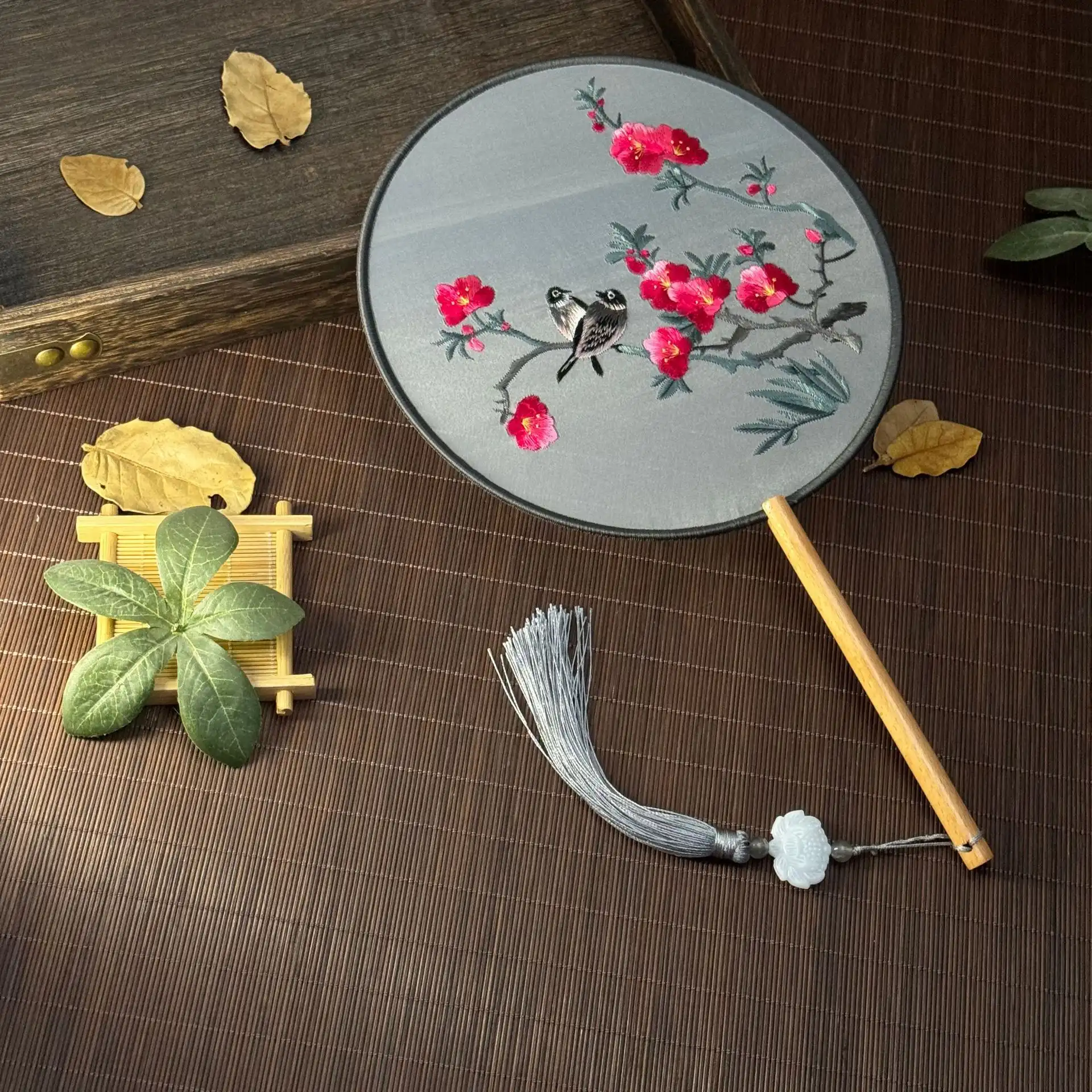 Home decoration display featuring embroidered round fan as elegant ornamental piece.
