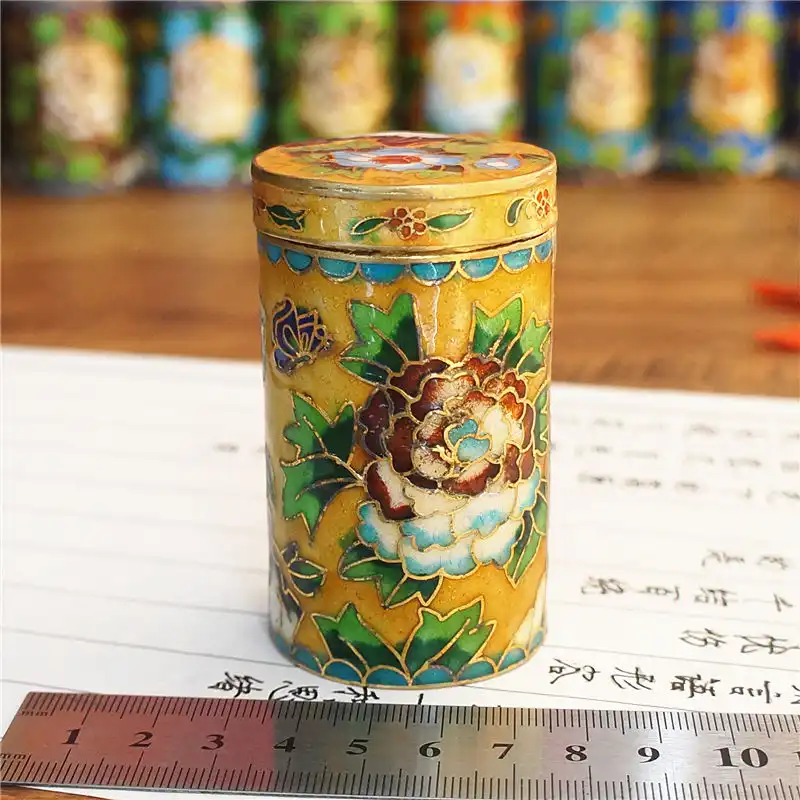 Artistic arrangement of cloisonne toothpick holder highlighting vintage desktop craft appeal.