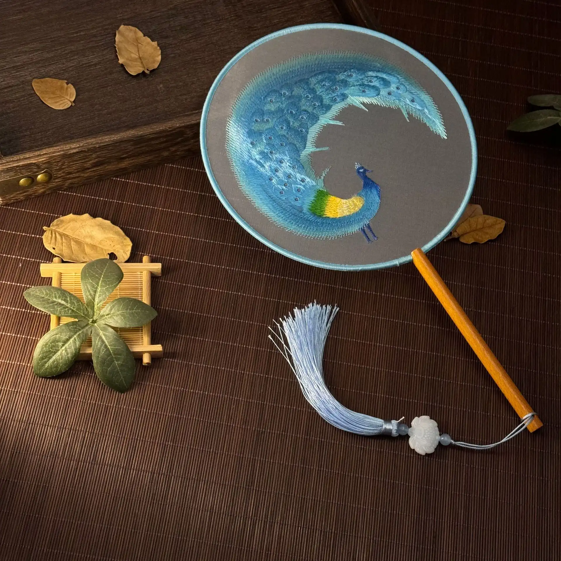 Double-sided embroidery technique showcase revealing identical patterns on both fan sides.