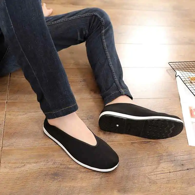 Traditional kung fu footwear on wooden floor showing authentic Chinese martial arts styling.