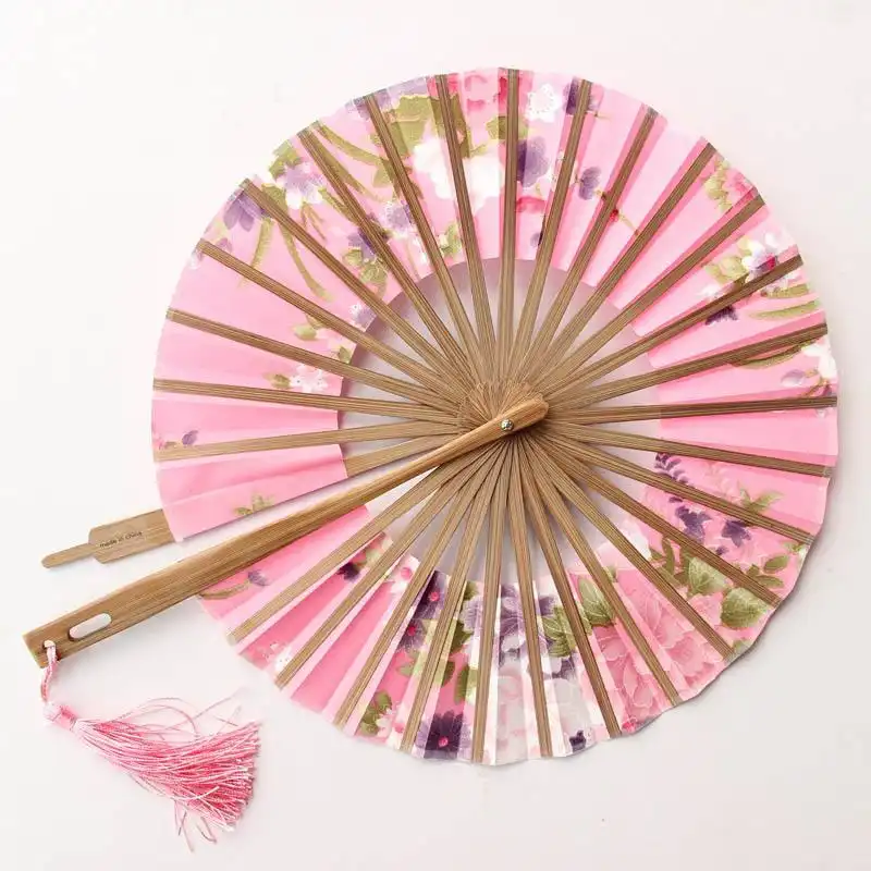 Elegant lady holding portable Japanese round fan demonstrating proper usage and style.