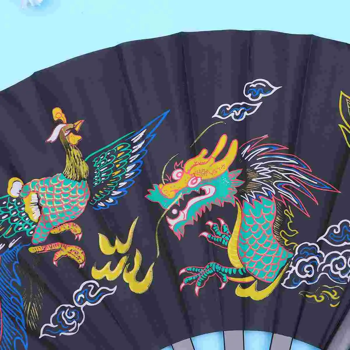 Martial artist performing Tai Chi form holding traditional style folding fan outdoors.