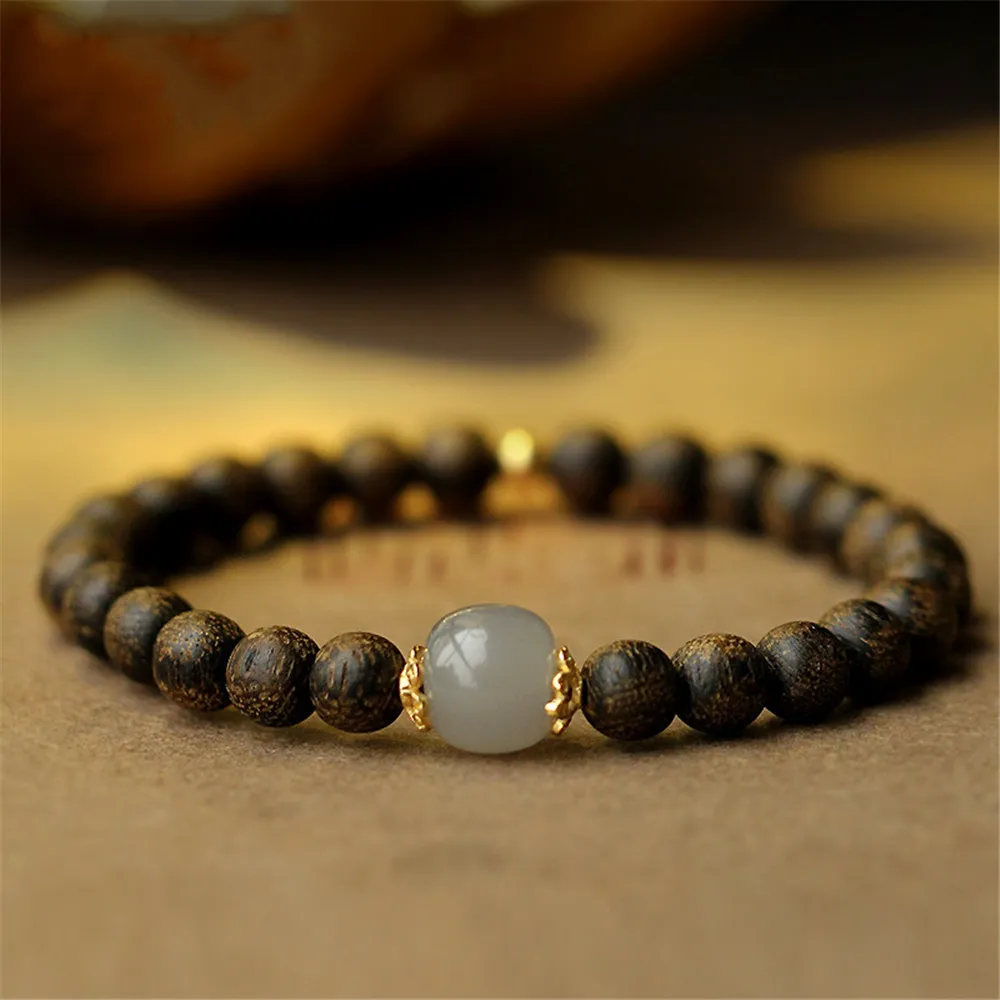 Close-up detail of premium agarwood Buddha beads showing natural wood grain and spiritual craftsmanship.