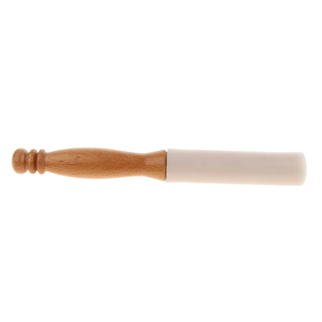 Hand demonstrating proper grip and technique for using rubber mallet with crystal bowl.