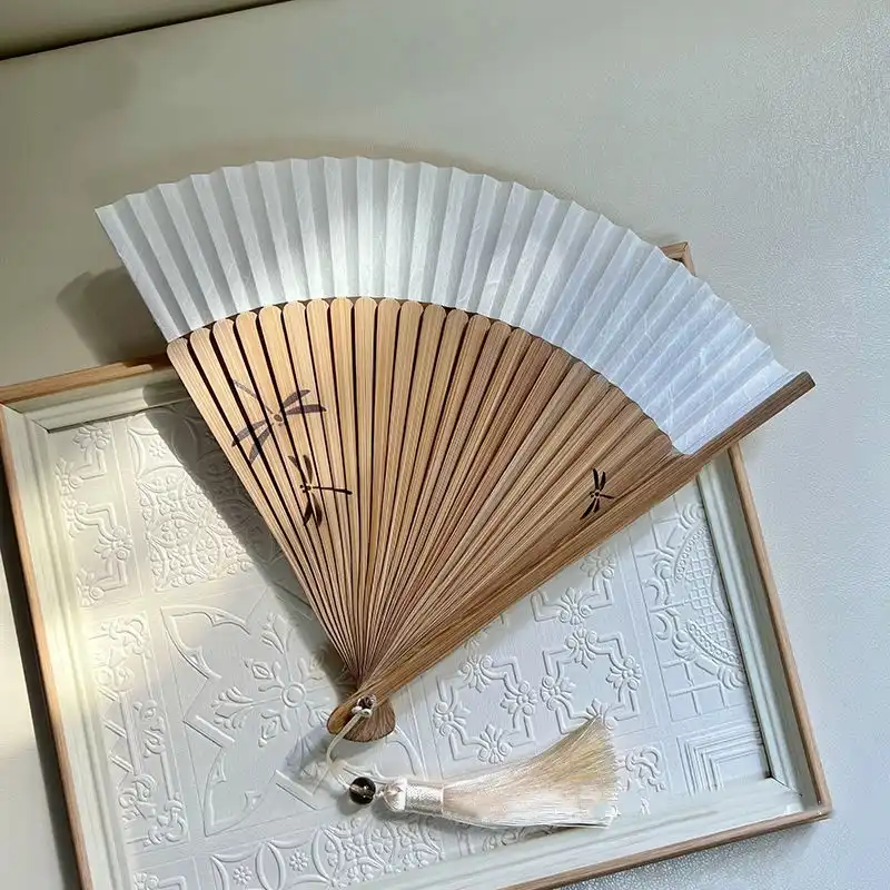 Size comparison of 21cm dragonfly fan next to everyday items for scale reference.