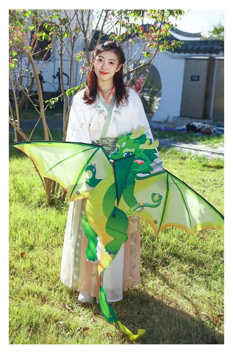 Child flying green Chinese dragon kite in open field with authentic cultural styling.