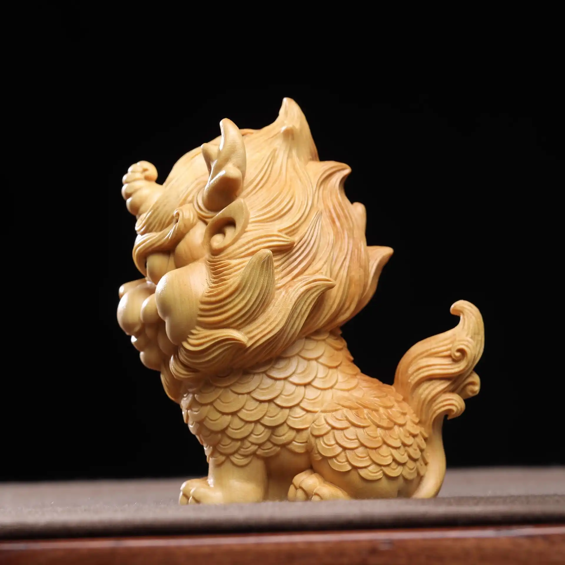 Side profile of carved wooden Qilin statue displaying traditional Chinese auspicious beast design.