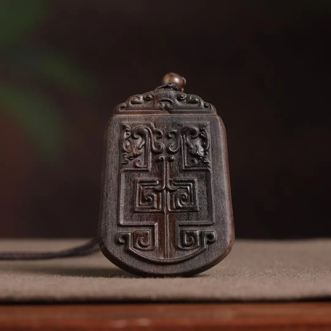 Close-up view of intricate antique patterns carved on both sides of wooden car ornament.