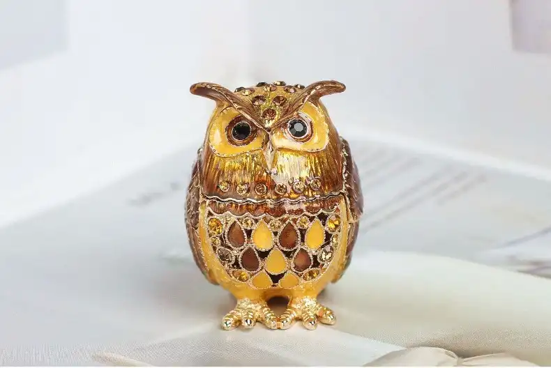 Traditional enamel owl box being used to store rings, earrings and small jewelry items.