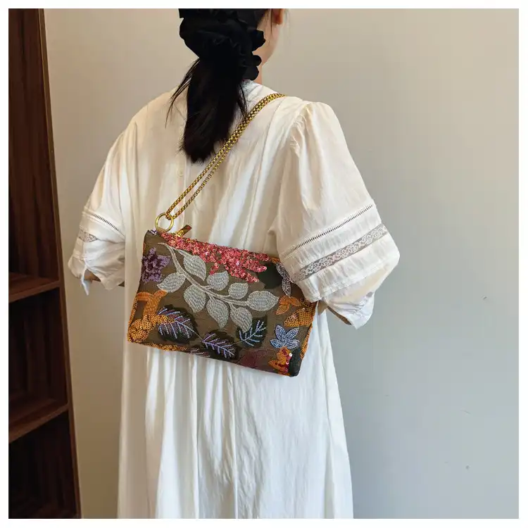 Fashion model carrying sequined embroidery clutch demonstrating elegant crossbody styling for parties.