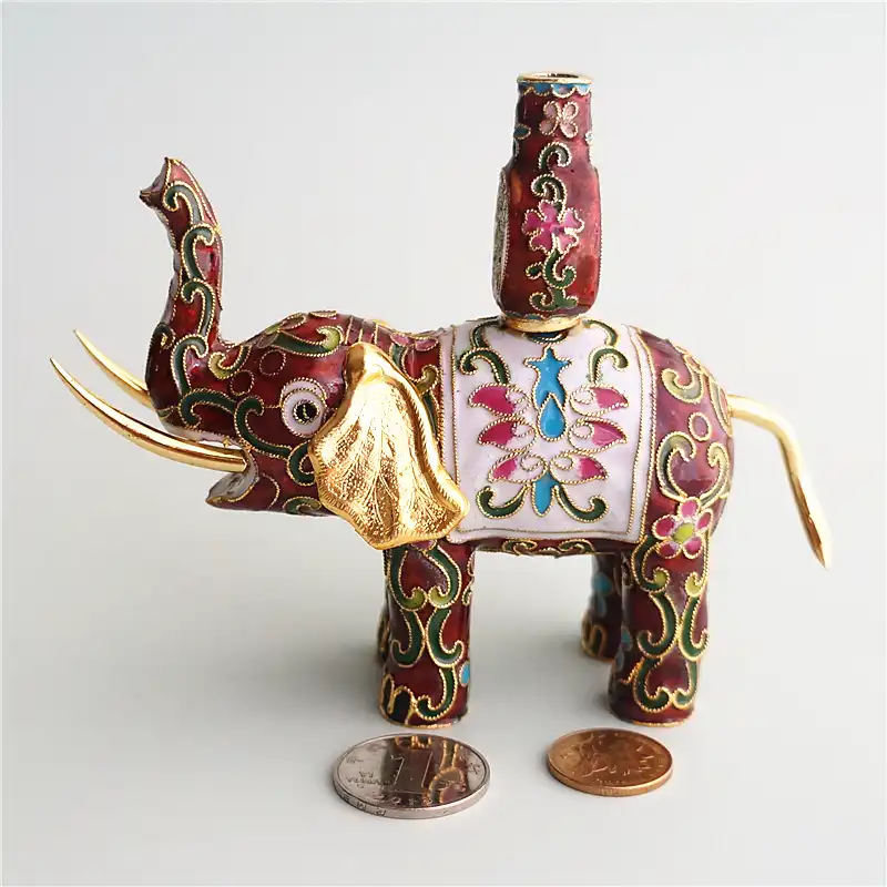 Traditional Chinese enamel colors including blues, greens, and reds on copper elephant.