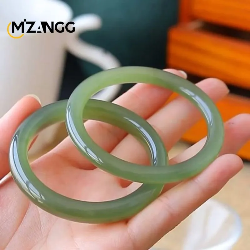 Close-up view of jade bangle displaying lake water green coloration and smooth polished surface finish.