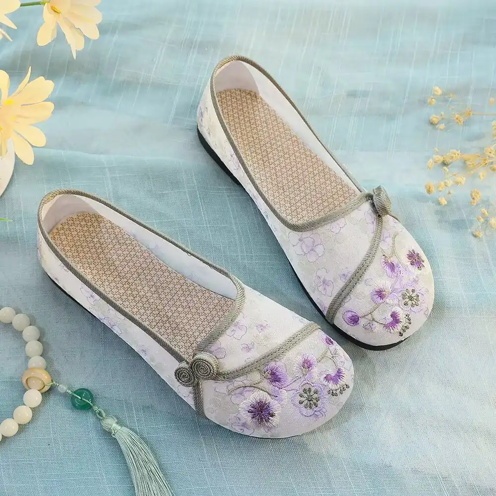 Side profile of traditional Chinese cloth shoes showing soft sole and slip-on design.