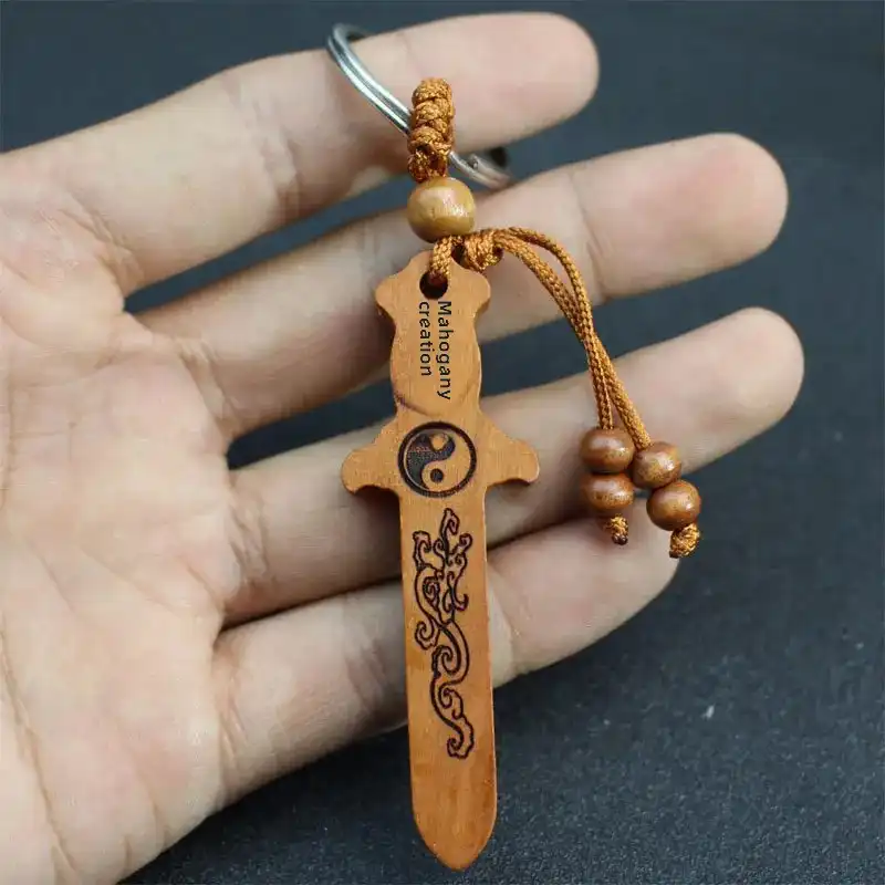 Wooden sword keychain hanging in car interior for feng shui protection and decorative accent.