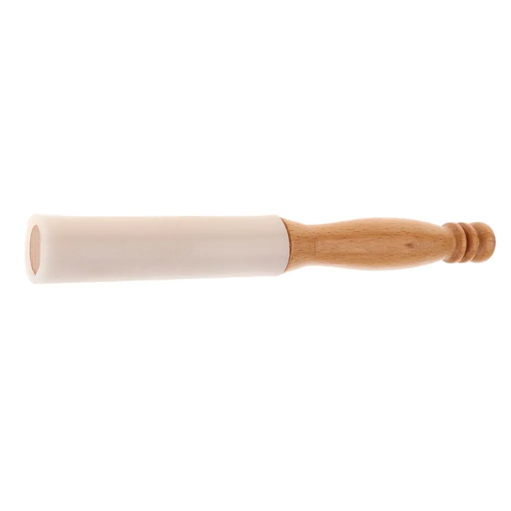 Rubber mallet creating sound vibrations by striking crystal singing bowl during meditation.