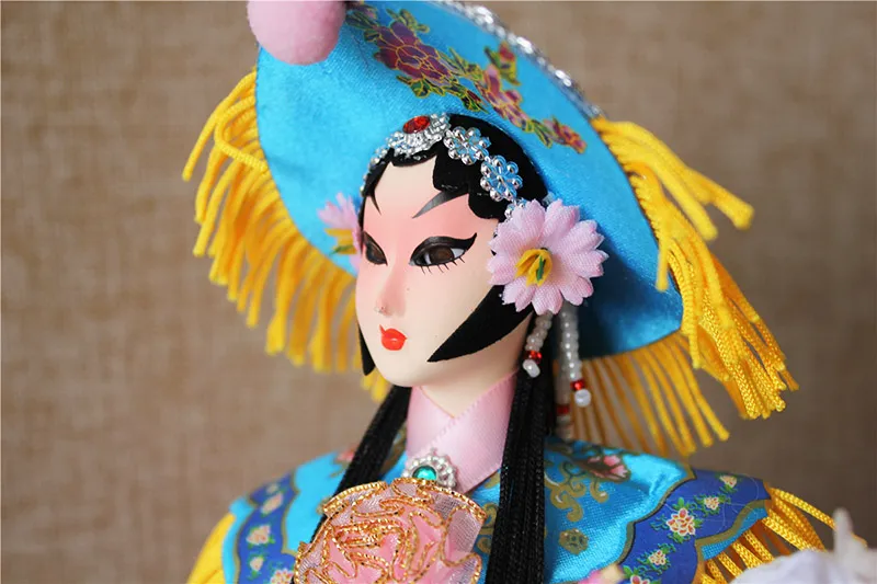 Back view of silk figurine showing detailed costume embroidery and craftsmanship.