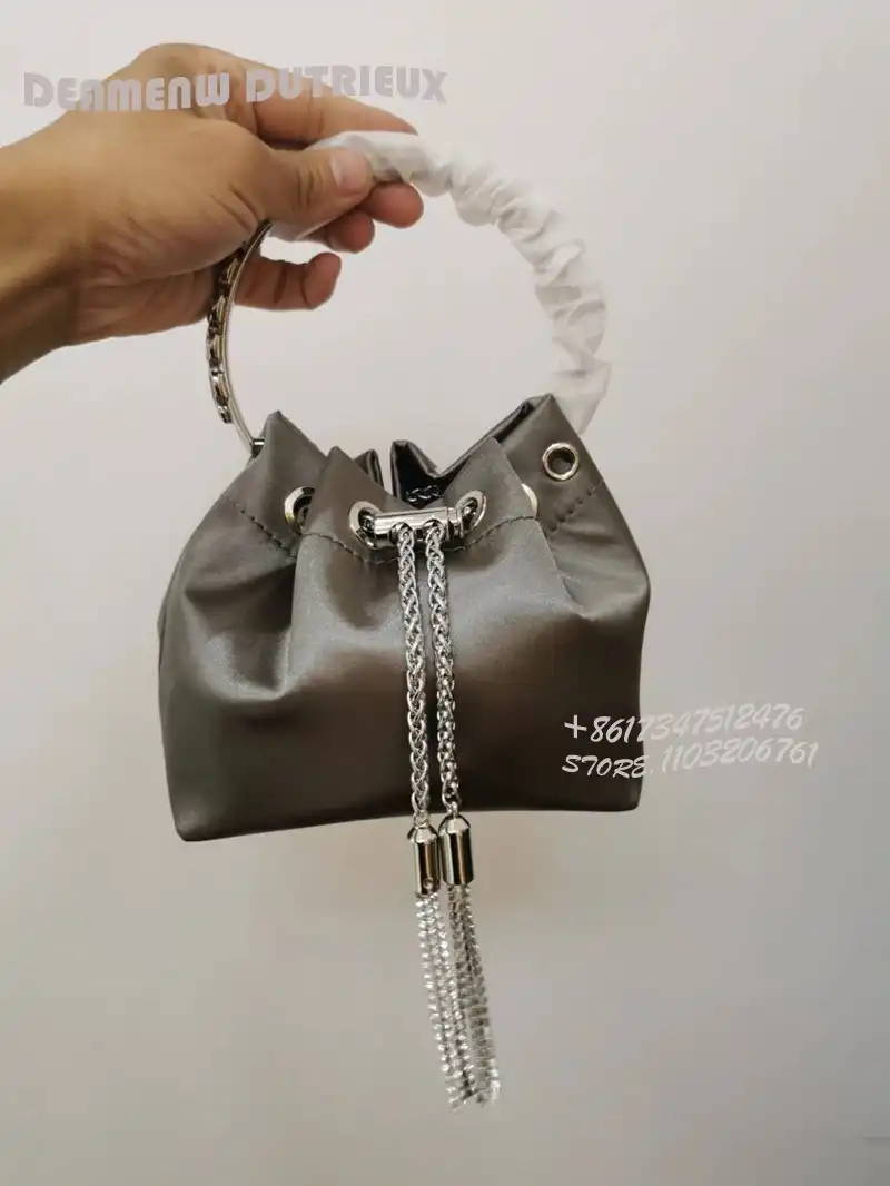 Model wearing crystal clutch as bracelet accessory at elegant party event.