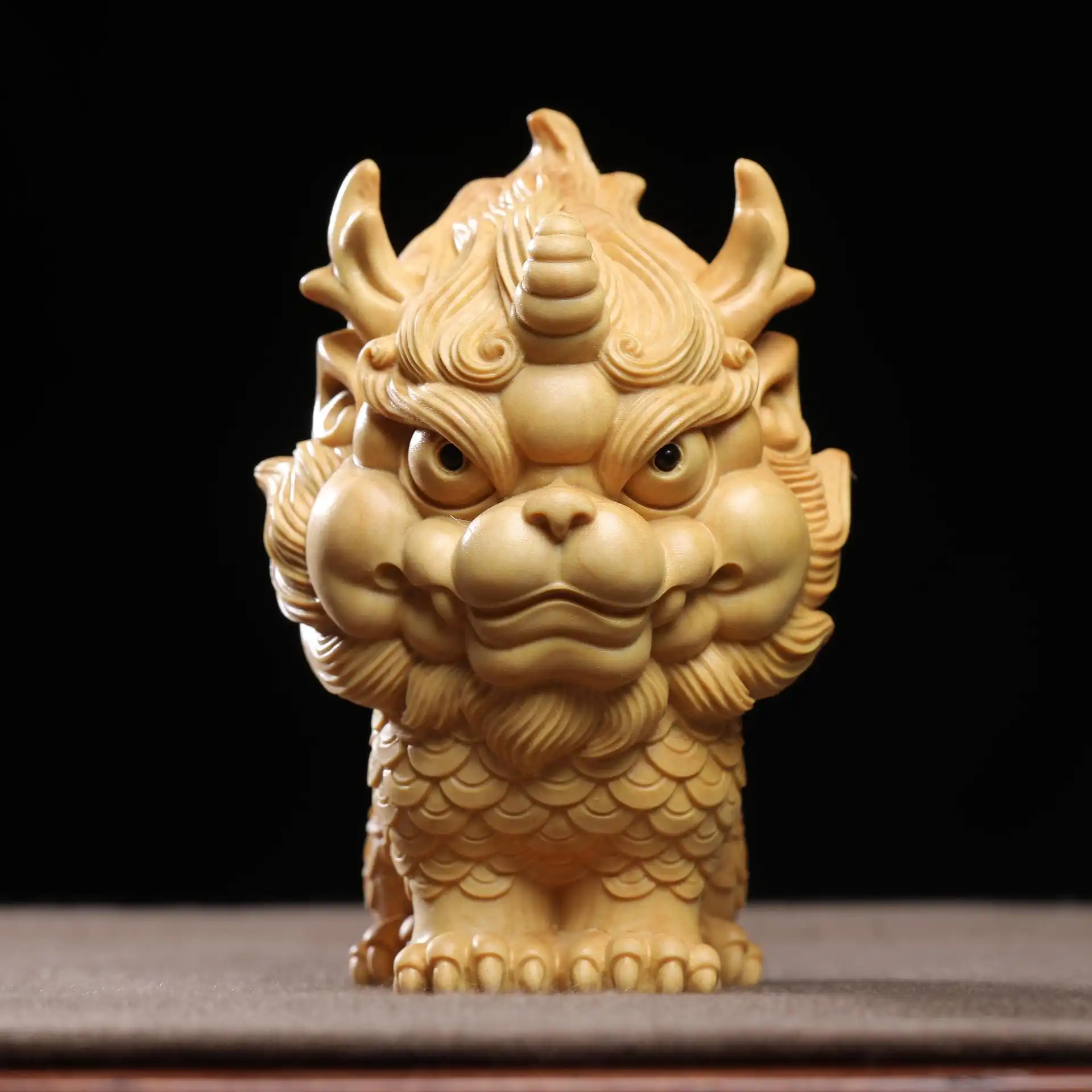 Wooden Qilin ornament displayed on office desk as feng shui decoration and workspace enhancement.