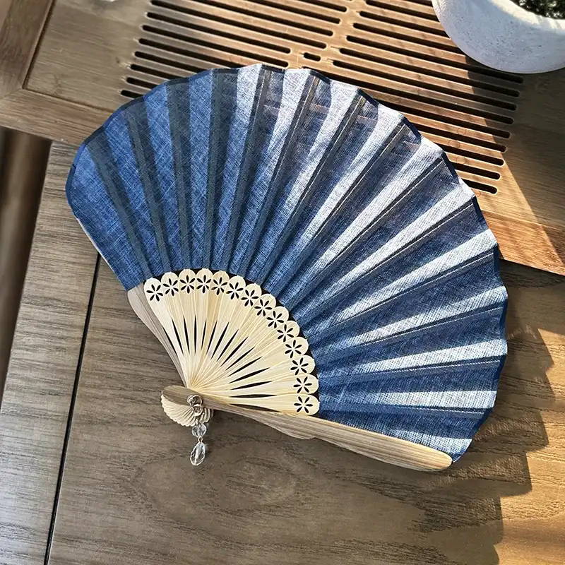 Solid color silk fabric covering stretched across shell shaped bamboo frame highlighting retro design.