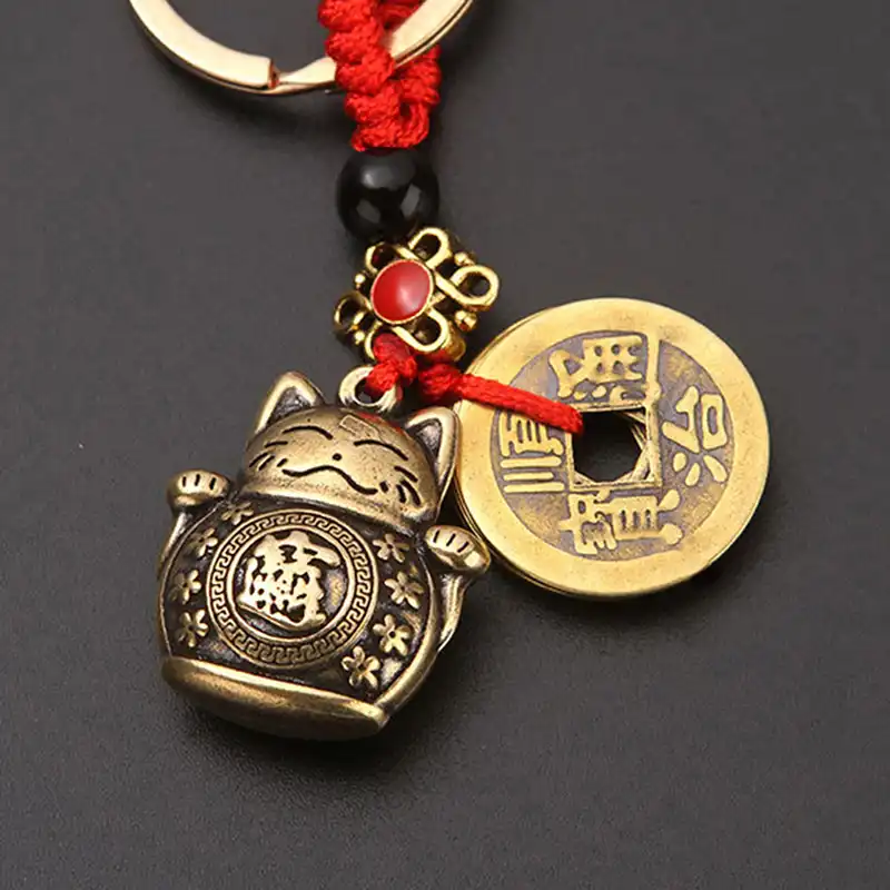 Detailed brass casting showing intricate lucky cat design and coin engravings.