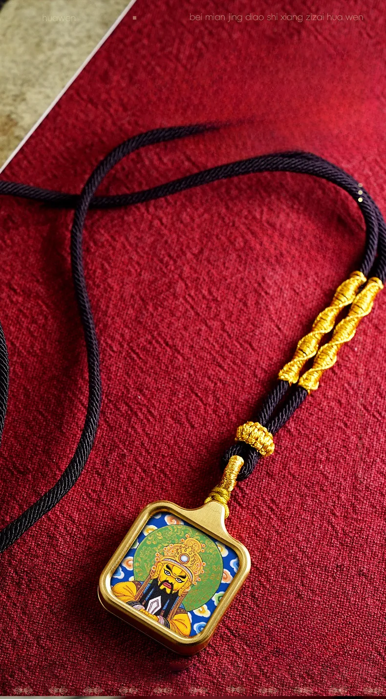 Close-up view of vintage Buddhist pendant showing geometric patterns and gold finish.