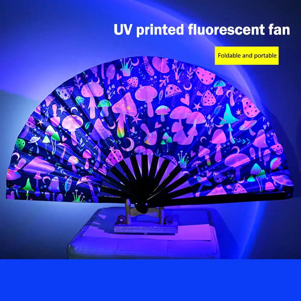 Festival crowd using glowing fluorescent fans under UV lights creating spectacular visual light show effect.