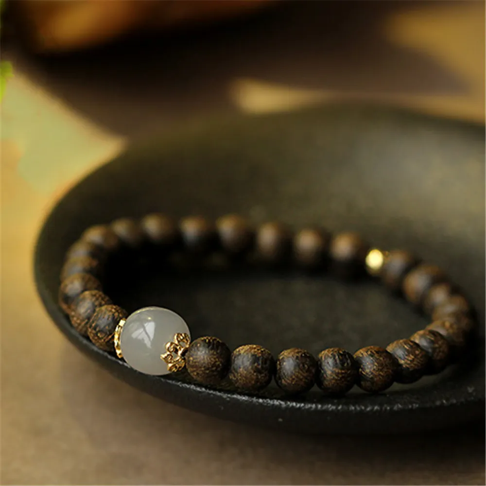 Buddha bracelet in meditation setting with incense and candles for home spiritual practice.