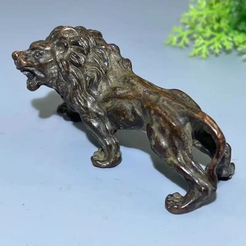 Close-up detail of antique bronze lion showing realistic features and patina development.