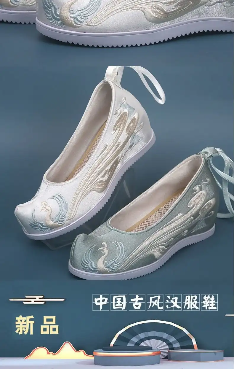 Pair of phoenix embroidered Chinese wedding flats arranged on traditional silk fabric background.