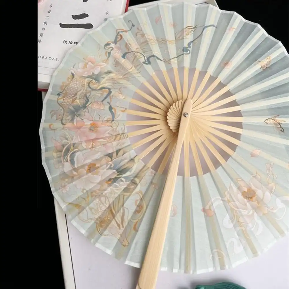 Travel scene showing compact folded fan easily fitting in handbag for portability.