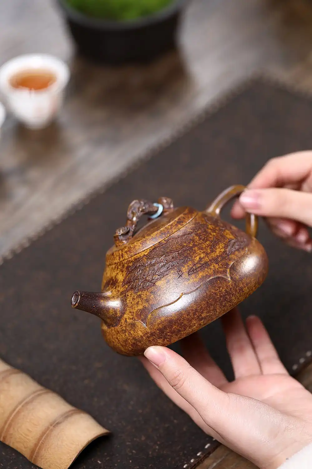 Tea brewing demonstration using keel gold sand teapot showing golden tea color and clarity.