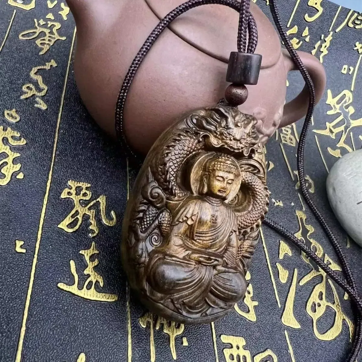 Side view showing depth and craftsmanship of carved Tathagata Buddha sandalwood pendant.