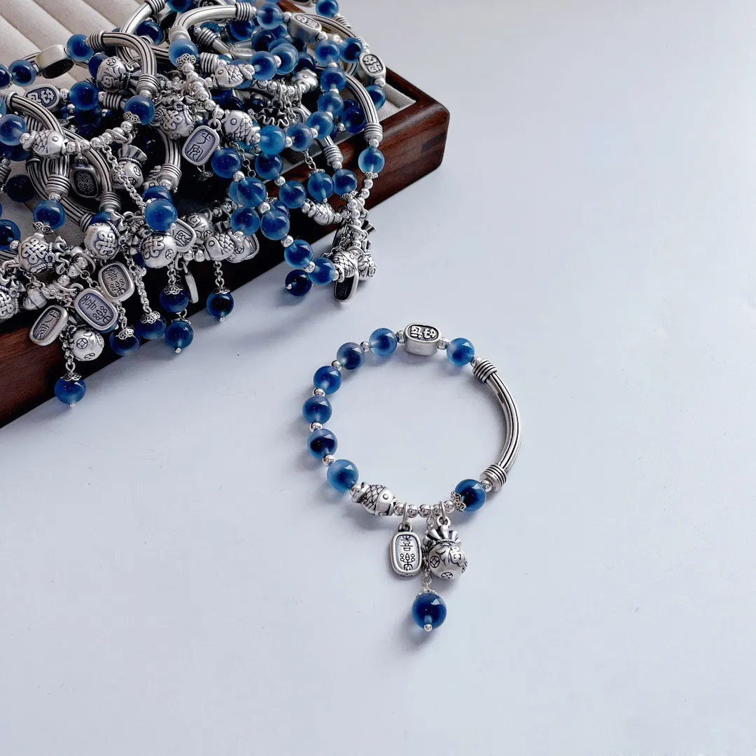 Traditional Chinese ethnic fish amulet charm on 925 silver bracelet showing cultural design.
